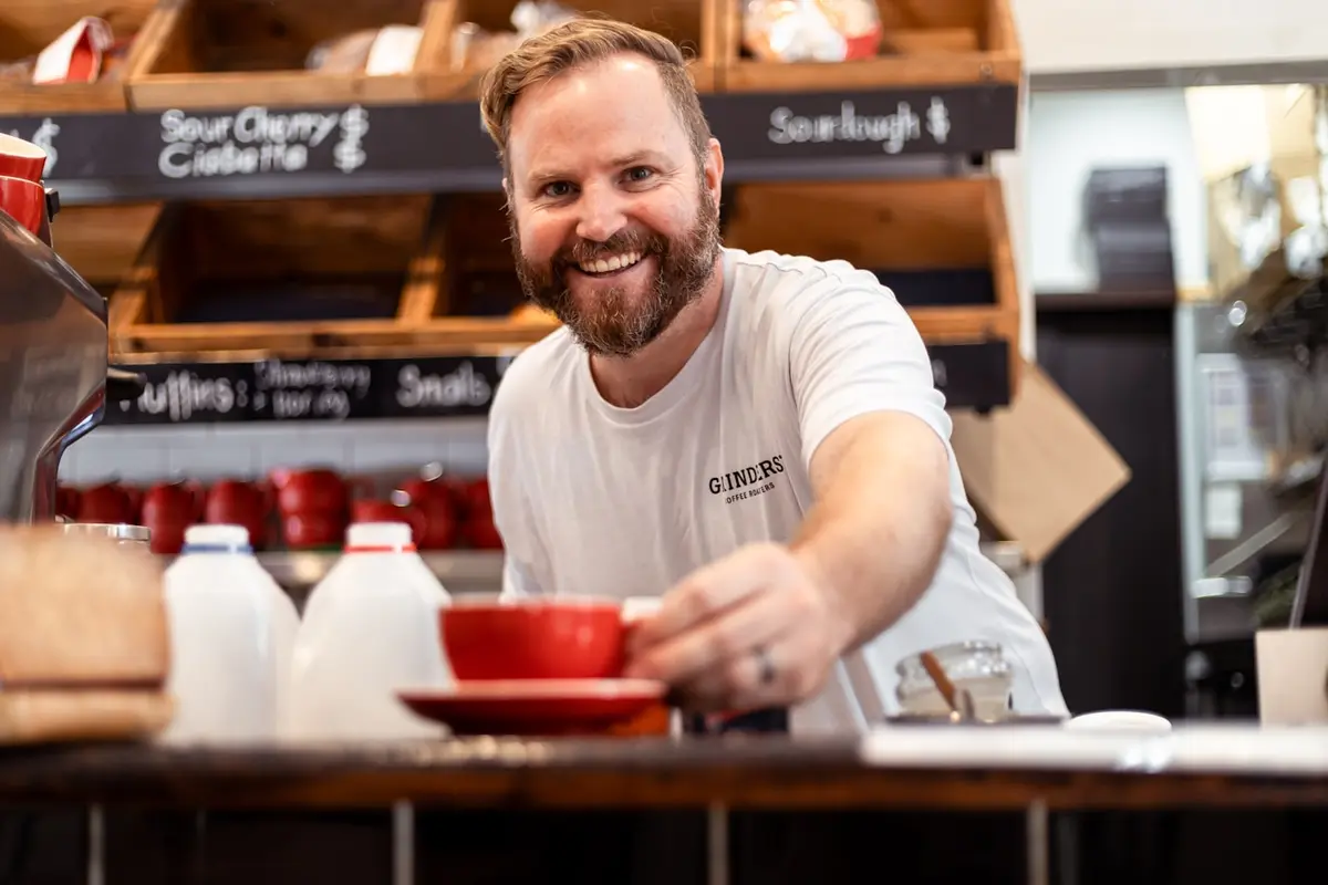 Barista serving coffee in an Australian cafe